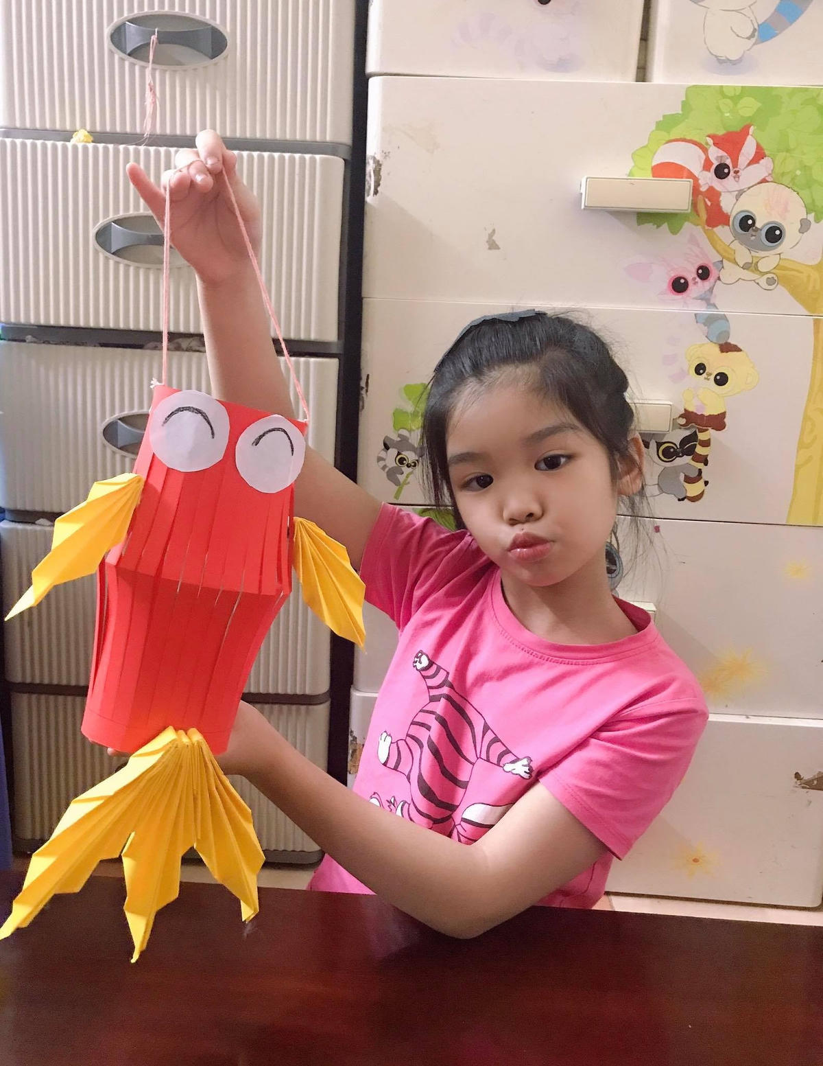 Bé Tuệ Lâm bên chiếc đèn lồng giấy tự làm. Ảnh: NVCC.