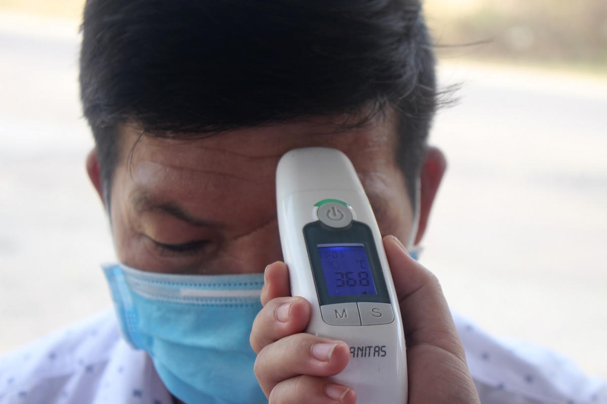 Đo thân nhiệt cho người dân ở chốn chặn quốc lộ 40B.