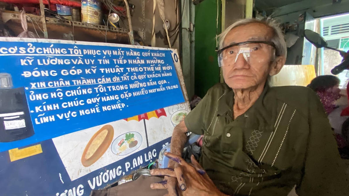 Ông Hoài Minh Phương bên tấm biển đang vẽ.