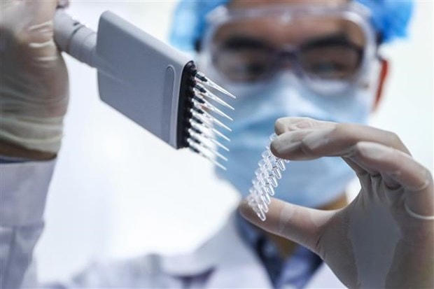 Nghiên cứu viên kiểm tra mẫu vaccine phòng dịch Covid-19 tại nhà máy của Tập đoàn công nghệ dược phẩm quốc gia Trung Quốc ở Bắc Kinh. (Ảnh: THX/TTXVN).