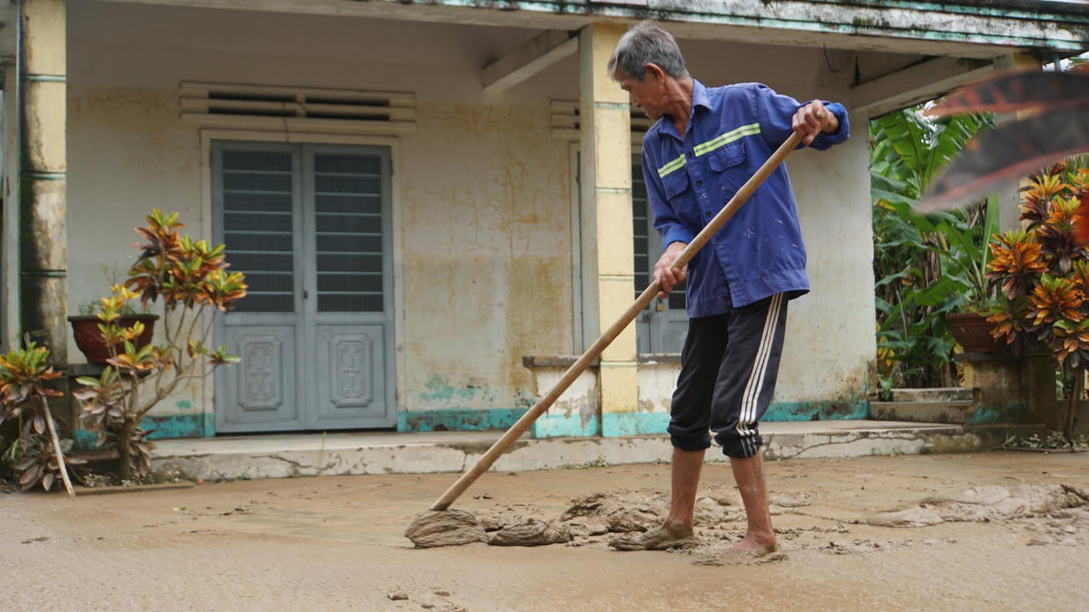 Ông Nguyễn Tấn Thành dùng kéo lớp bùn non ra ngoài.