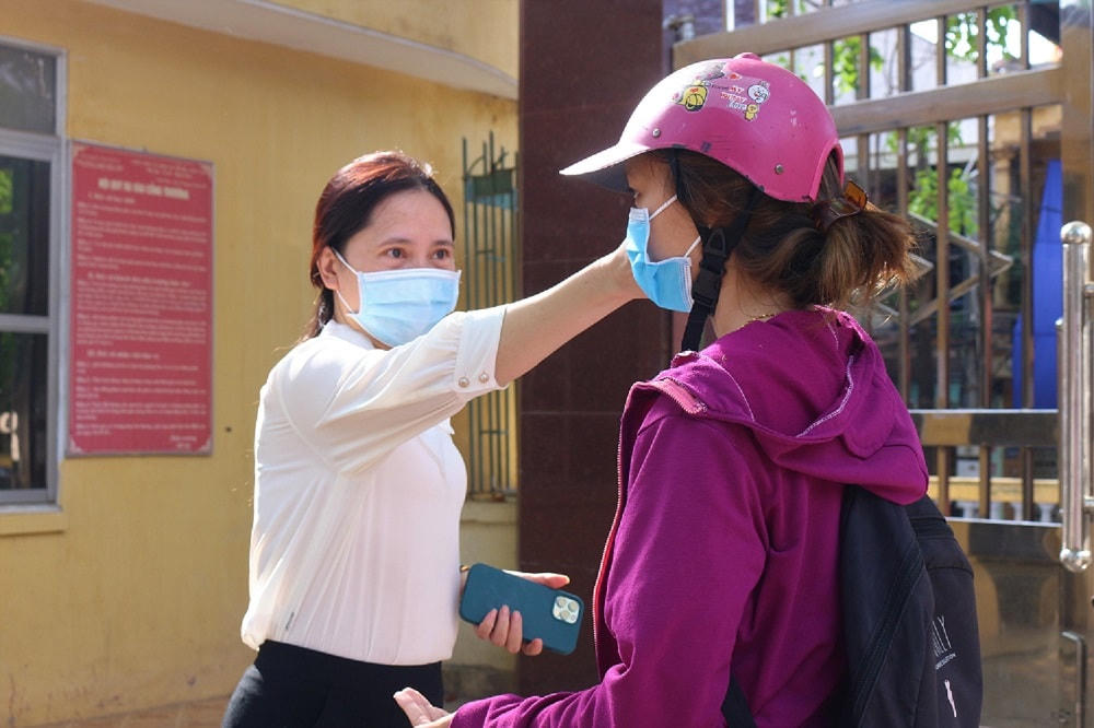 Học sinh được kiểm tra thân nhiệt trước khi vào lớp học.