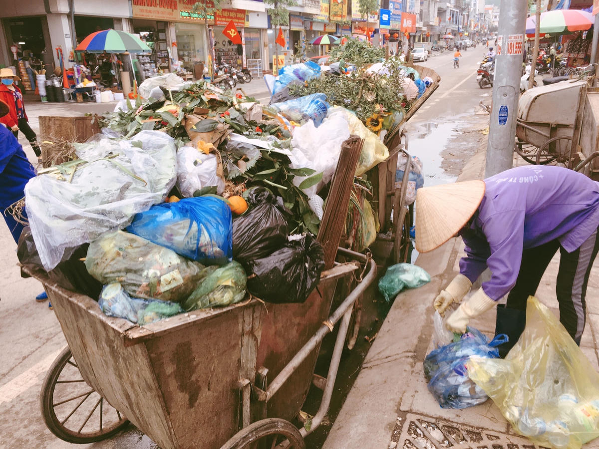 Rác thải của chợ Cái Rồng và các khu dân cư xung quanh đều tập trung hết về cổng chợ để chờ xe rác đến xử lí.