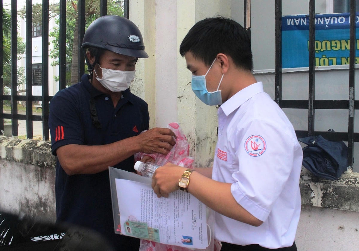 Em Phôn đang chia sẻ bài thi môn toán với ba mình.
