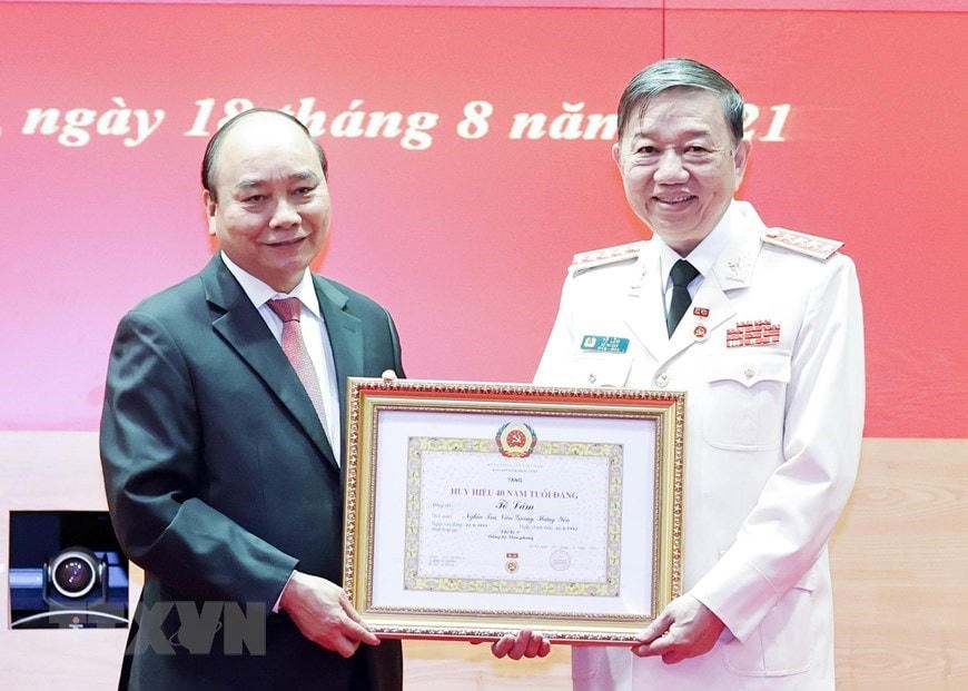 Chủ tịch nước Nguyễn Xuân Phúc trao tặng Huy hiệu 40 năm tuổi Đảng cho Đại tướng Tô Lâm, Ủy viên Bộ Chính trị, Bộ trưởng Bộ Công an. (Ảnh: Thống Nhất/TTXVN).