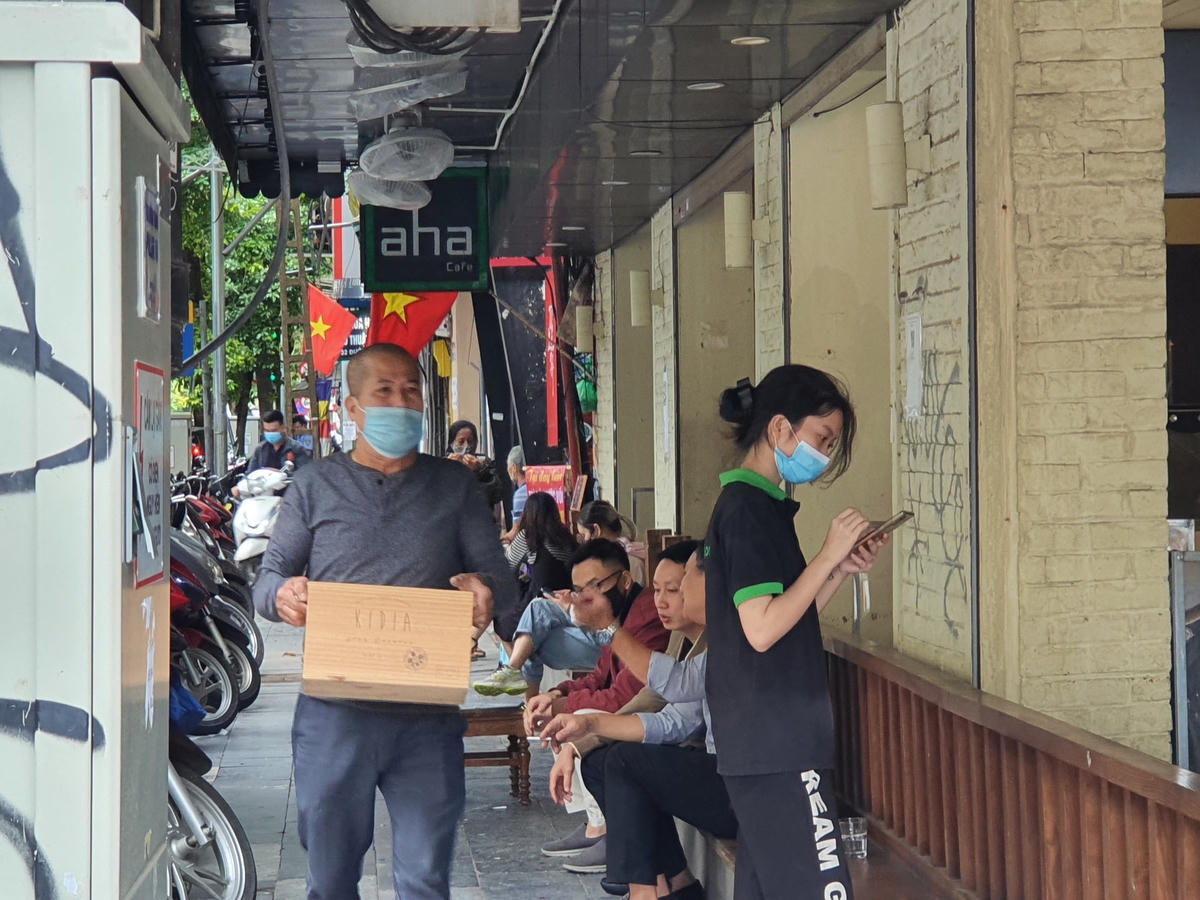 Các nhân viên tất bật đón khách dù thời tiết không mấy thuận lợi trong ngày đầu mở bán tại chỗ trở lại.
