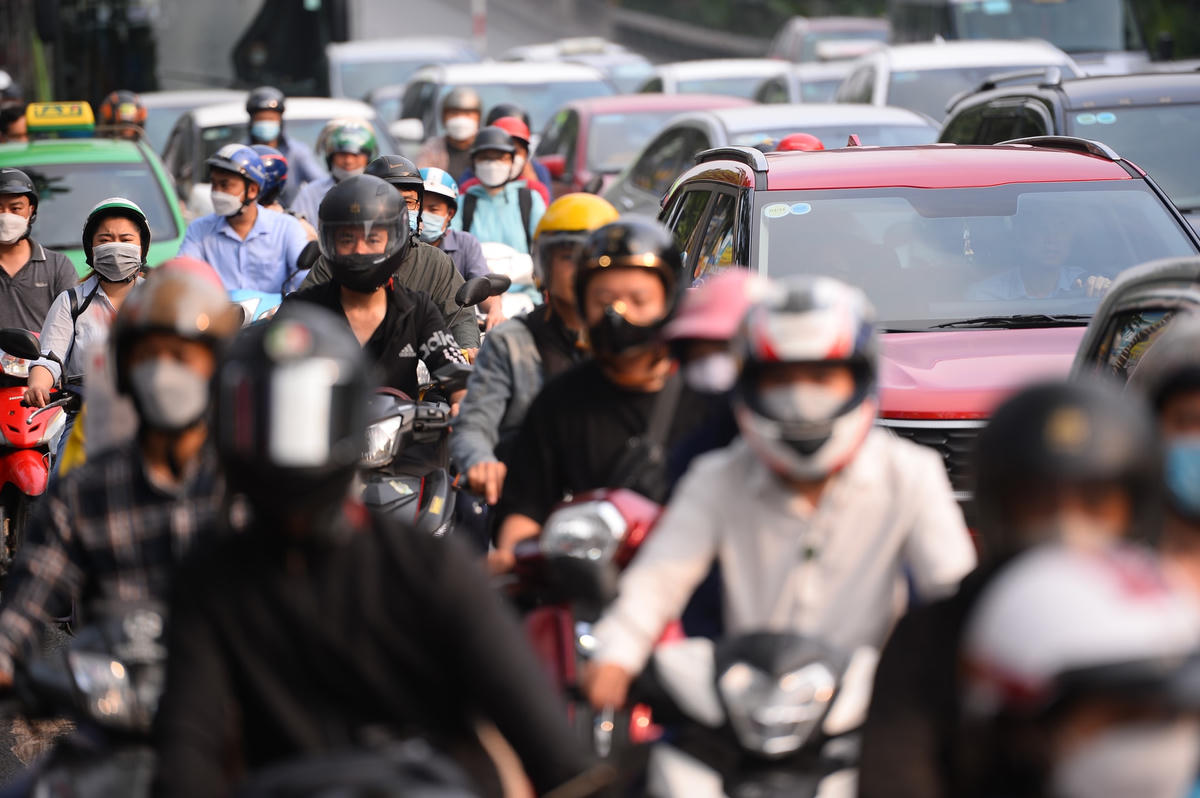 Nhiều gia đình di chuyển khó khăn bằng xe máy hướng từ trung tâm ra ngoại thành.