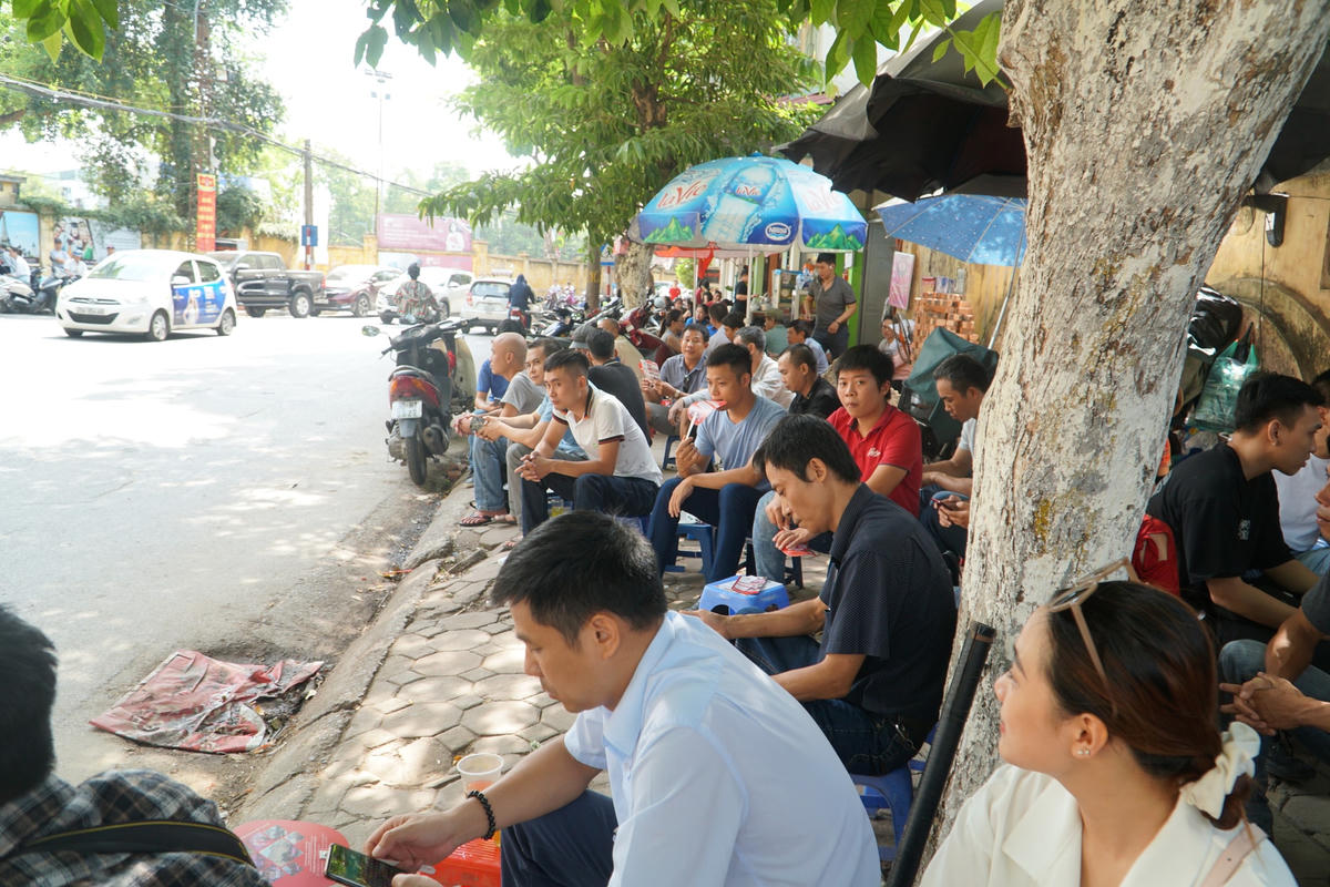 Phụ huynh lo lắng ngồi đợi con và tránh nóng tại các quán nước trên vỉa hè.