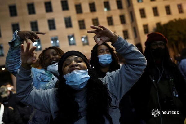 Cử tri phản ứng vui mừng khi xem kết quả sớm trên TV ngoài trời tại Black Lives Matter Plaza.  