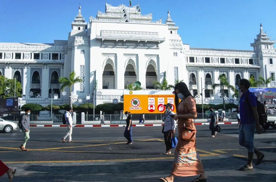 Người dân đi ngang qua Tòa thị chính Yangon, ngày 2/2/2021, một ngày sau khi quân đội Myanmar nắm chính quyền, bắt giữ nhà lãnh đạo được bầu cử dân chủ Aung San Suu Kyi và áp đặt tình trạng khẩn cấp kéo dài một năm.