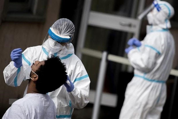 Nhân viên y tế lấy mẫu dịch xét nghiệm Covid -19 cho người dân tại Rome, Italy. (Ảnh: AFP/TTXVN).  