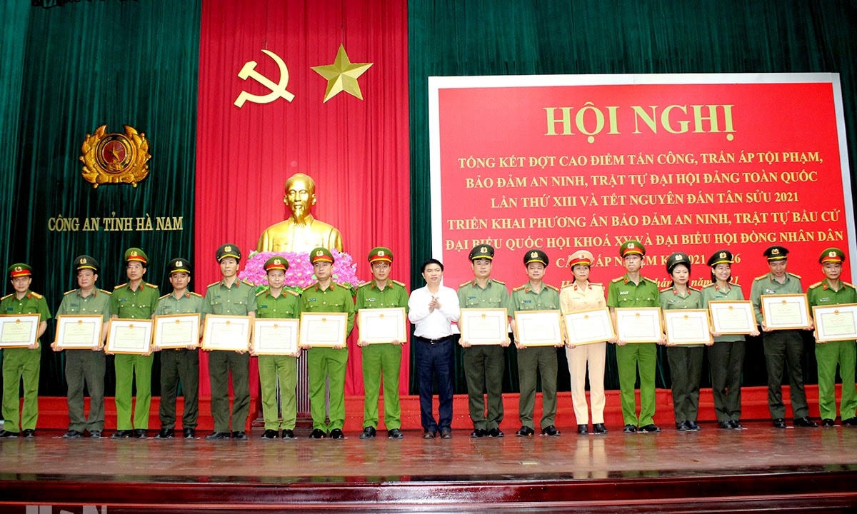 Chủ tịch UBND tỉnh Hà Nam Trương Quốc Huy (đứng giữa) trao thưởng cho các tập thể, cá nhân thuộc lực lượng Công an tỉnh.