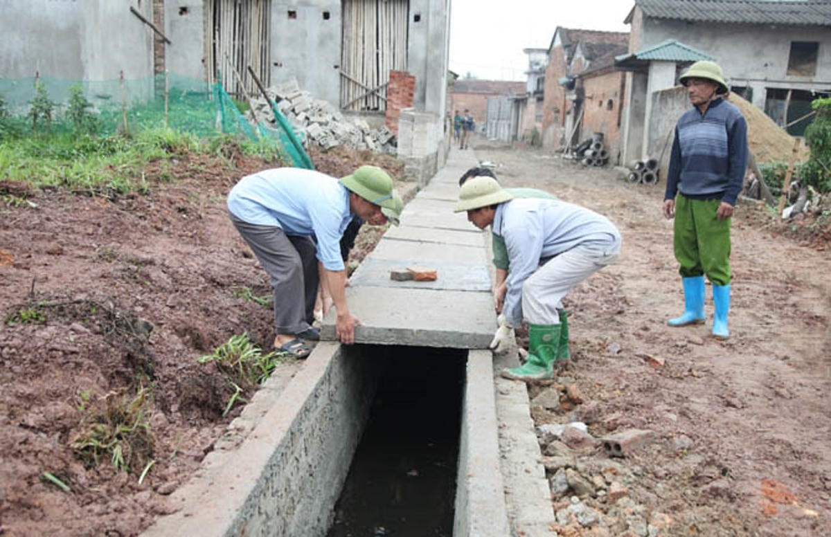 Người dân tham gia xây dựng cống, rãnh thoát nước thải. Ảnh: Lê Vân.