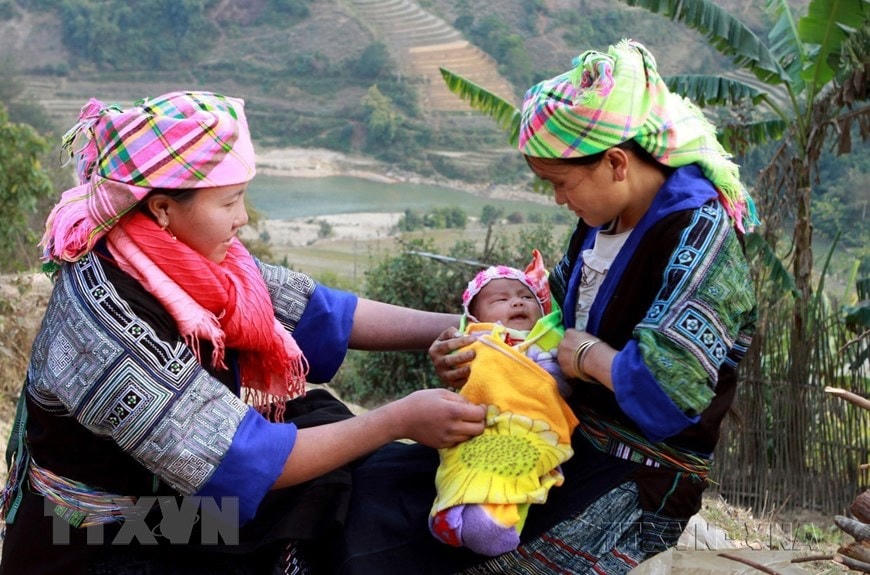 Cô đỡ thôn bản huyện Mù Cang Chải, tỉnh Yên Bái (bên trái) hướng dẫn bà mẹ chăm sóc trẻ sơ sinh. (Ảnh: Dương Ngọc/TTXVN)  