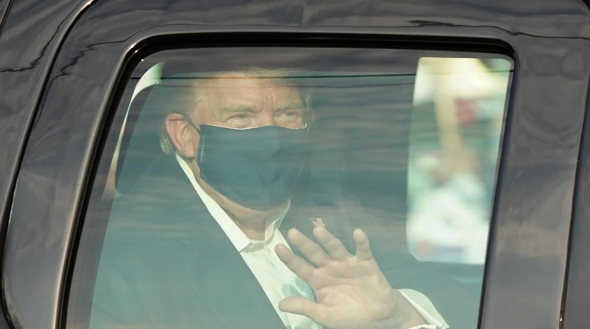 Tổng thống Mỹ Donald Trump đeo khẩu trang ngồi trong chiếc xe SUV màu đen.