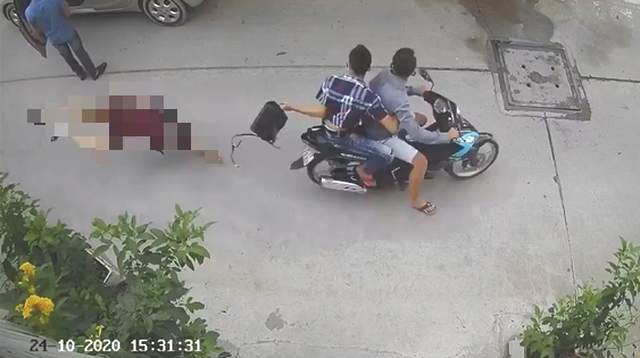 Hai nghi phạm đi xe máy cướp giật túi xách khiến nạn nhân té ngã xuống đường - Ảnh camera ghi lại.