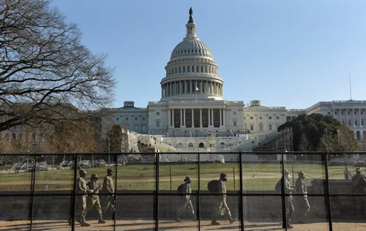Lực lượng Vệ binh Quốc gia đi dọc hàng rào bảo vệ quanh Điện Capitol Mỹ. Ảnh: Reuters.