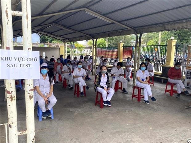 Công nhân Công ty trách nhiệm hữu hạn Nagata Việt Nam tại Khu chế xuất Tân Thuận, Quận 7 được lấy mẫu xét nghiệm Covid-19. (Ảnh: TTXVN phát)