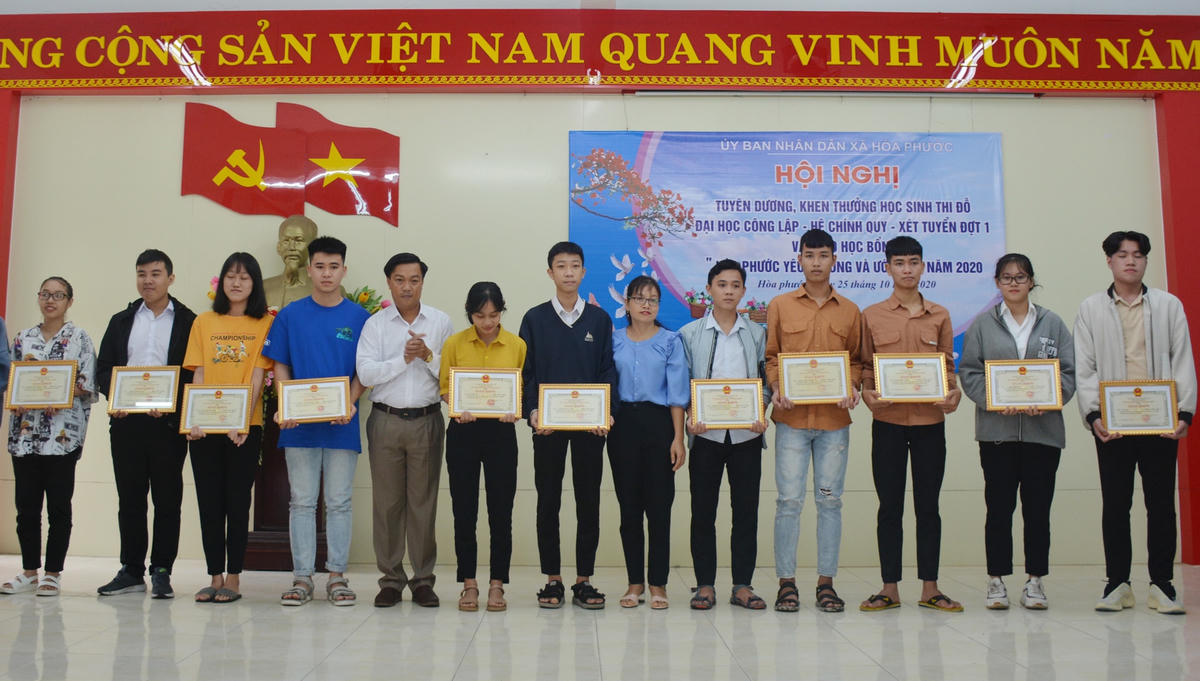 Chủ tịch UBND xã Hòa Phước Trần Bùi Quốc Bình (thứ 5, trái sang) tặng giấy khen các em thi đỗ đại học công lập hệ chính quy năm 2020.