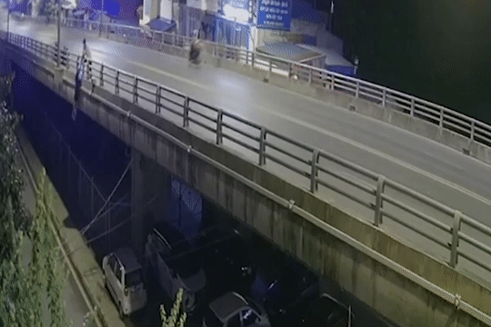 Cô gái trẻ tuột khỏi tay bạn trai và rơi xuống vỉa hè bên dưới, cách mặt cầu khoảng 4-5 m. Ảnh cắt từ clip.