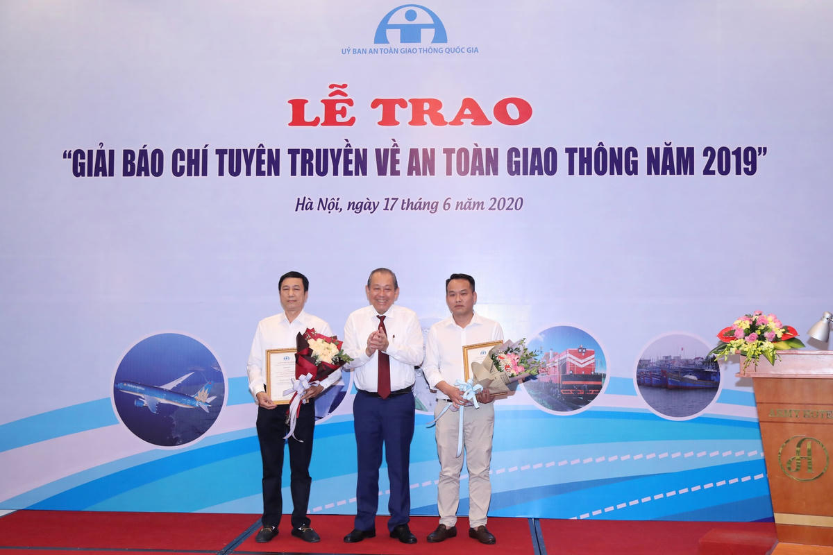 Phó Thủ tướng Thường trực Trương Hòa Bình trao giải Nhất cho nhà báo Mai Ngọc Tuyền (trái), đại diện nhóm tác giả báo Đại Đoàn Kết. Ảnh: Quang Vinh.
