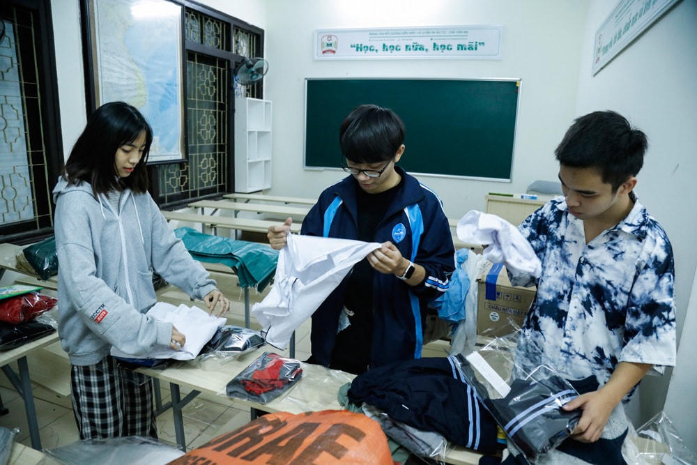 Các bạn trẻ trong nhóm phân loại quần áo từ các nhà hảo tâm gửi đến.