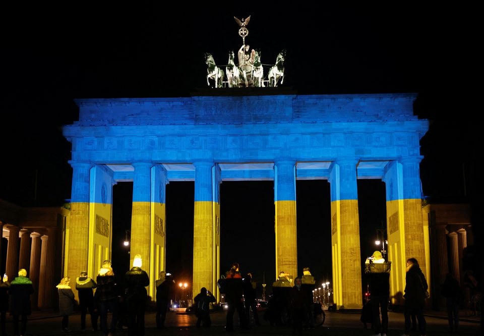 Cổng Brandenburg được chiếu sáng bởi sắc xanh vàng - màu quốc kỳ Ukraine, ở Berlin (Đức). Ảnh: Reuters / Michele Tantussi. 