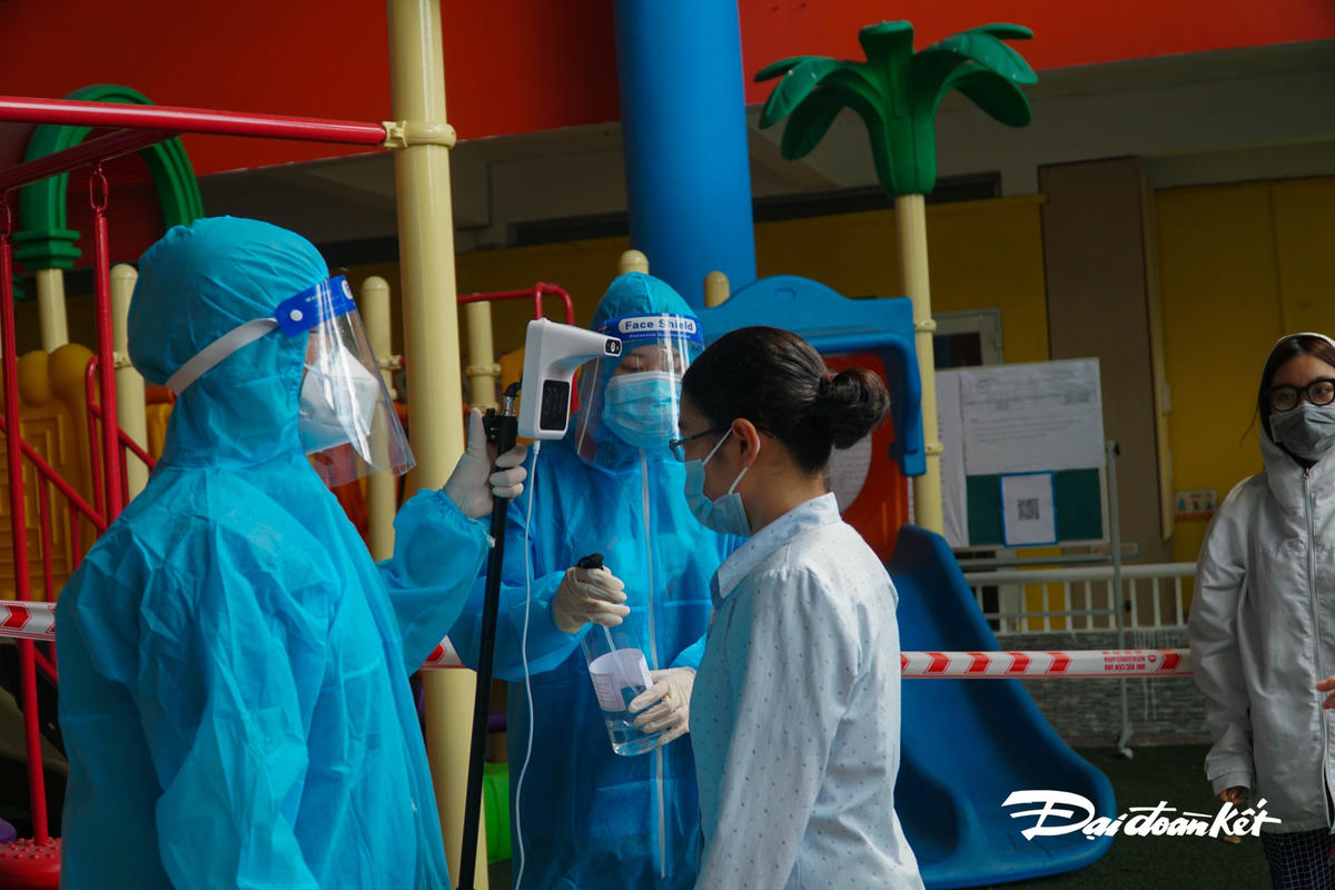 Người dân vào tiêm phải được kiểm tra thân nhiệt.