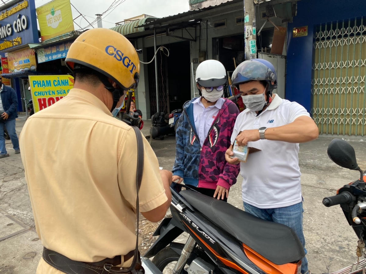 Phụ huynh chở con đi ngược chiều trên quốc lộ 22 bị dừng lại nhắc nhở, chưa xử phạt.