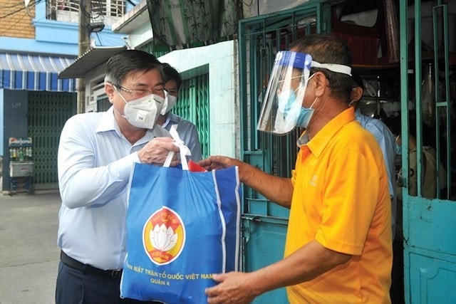 Chủ tịch UBND TP HCM Nguyễn Thành Phong đại diện lãnh đạo thành phố trao tận tay một hộ dân "túi an sinh".