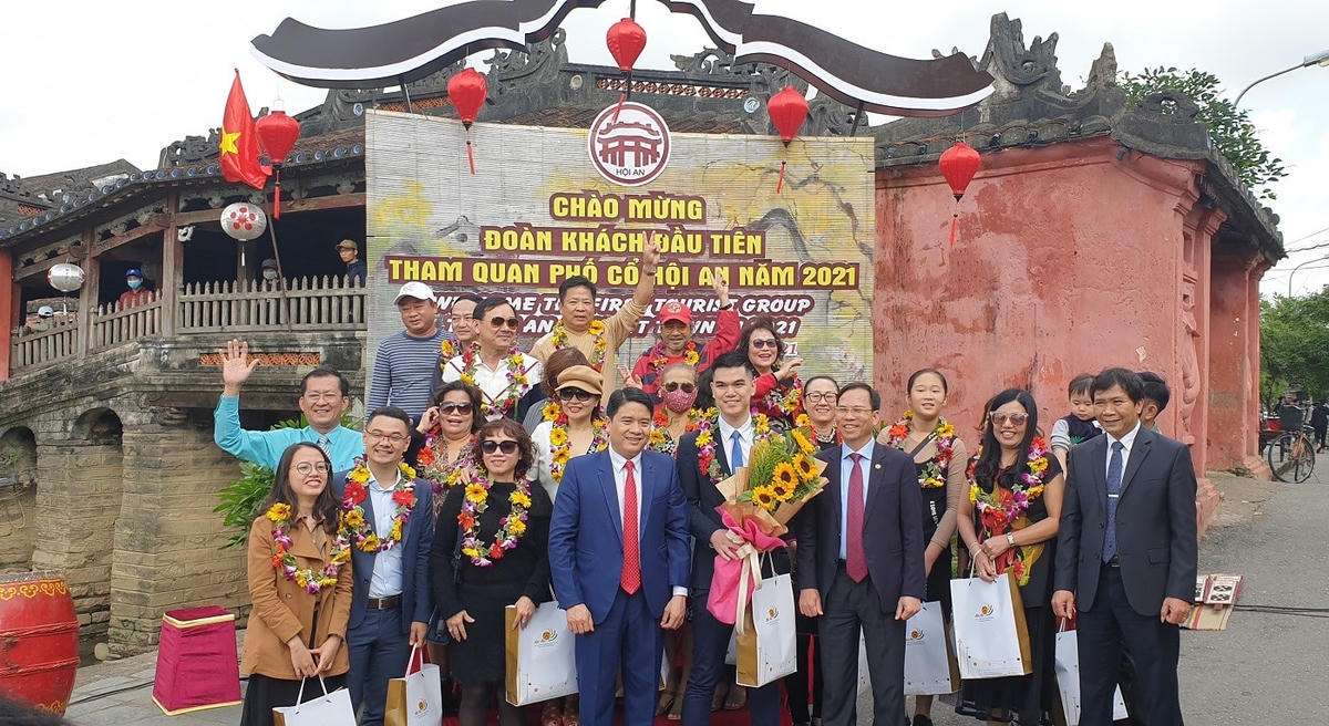 Đoàn khách đầu tiên đến tham quan phố cổ Hội An chụp ảnh lưu niệm.