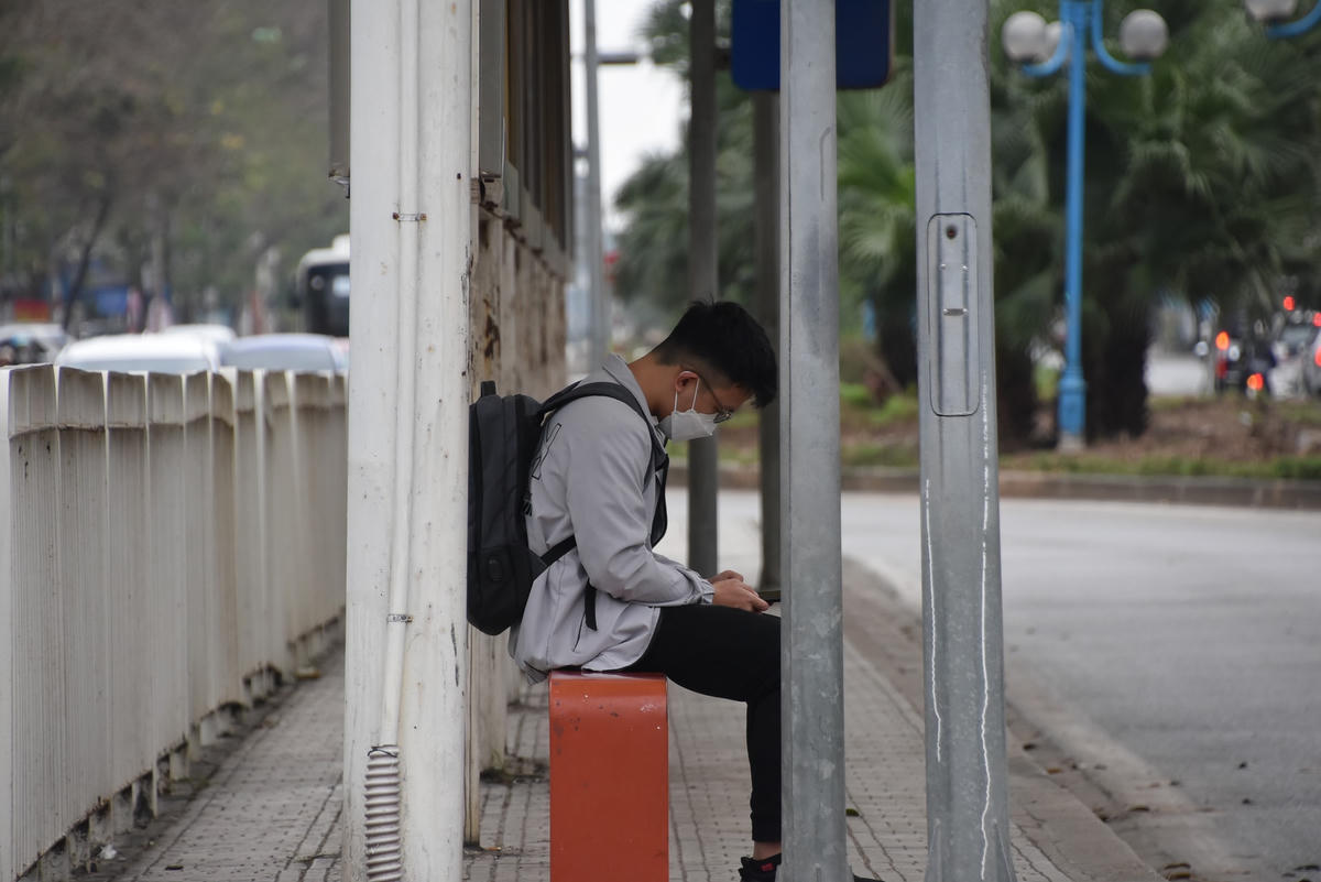 Một vị khách lặng lẽ ngồi chờ xe tại điểm trung chuyển Hoàng Quốc Việt.