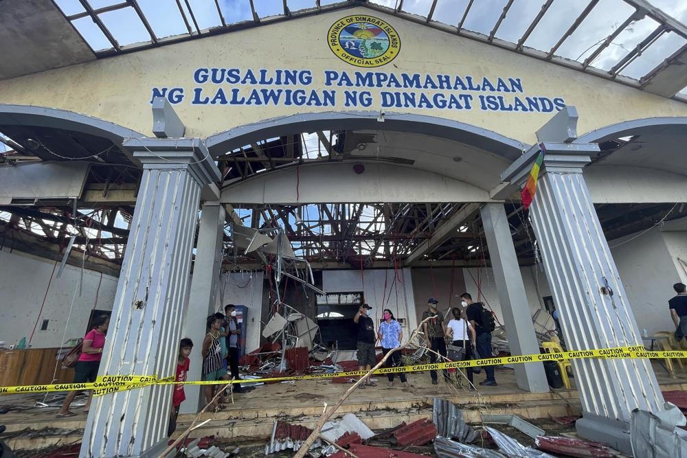 Người dân đang kiểm tra thiệt hại do bão Rai tại quần đảo Dinagat, miền nam Philippines. Ảnh: AP.