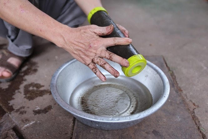 Một người dân xã Phúc Lâm “giới thiệu” lõi lọc nước bám cặn đen xì.