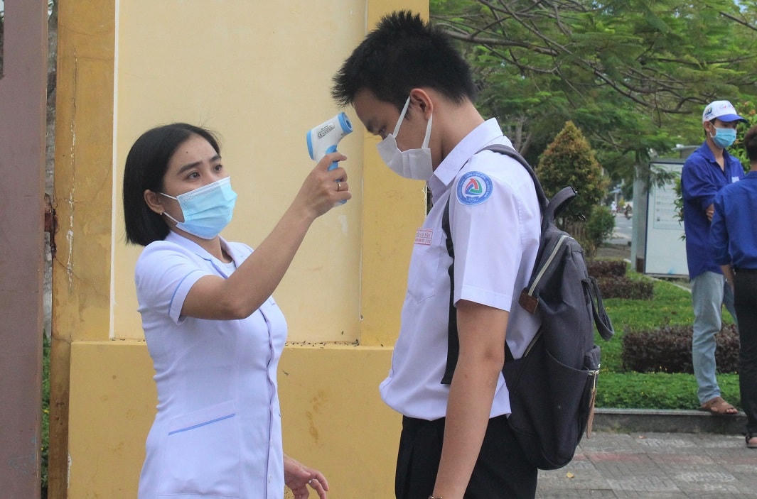 Nhân viên đo thân nhiệt cho thí sinh ở điểm thi Trường Trần Cao Vân.