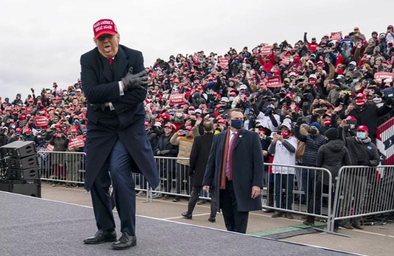 Cựu Tổng thống Donald Trump biểu cảm về cái lạnh khi ông đến tham dự một cuộc vận động tranh cử tại Công viên các Ngôi sao Thể thao Michigan, Chủ nhật, năm 2020.