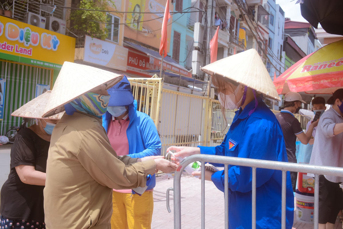 Mỗi người dân khi tham gia lấy cơm đều được sát khuẩn, đảm bảo công tác phòng dịch Covid-19.
