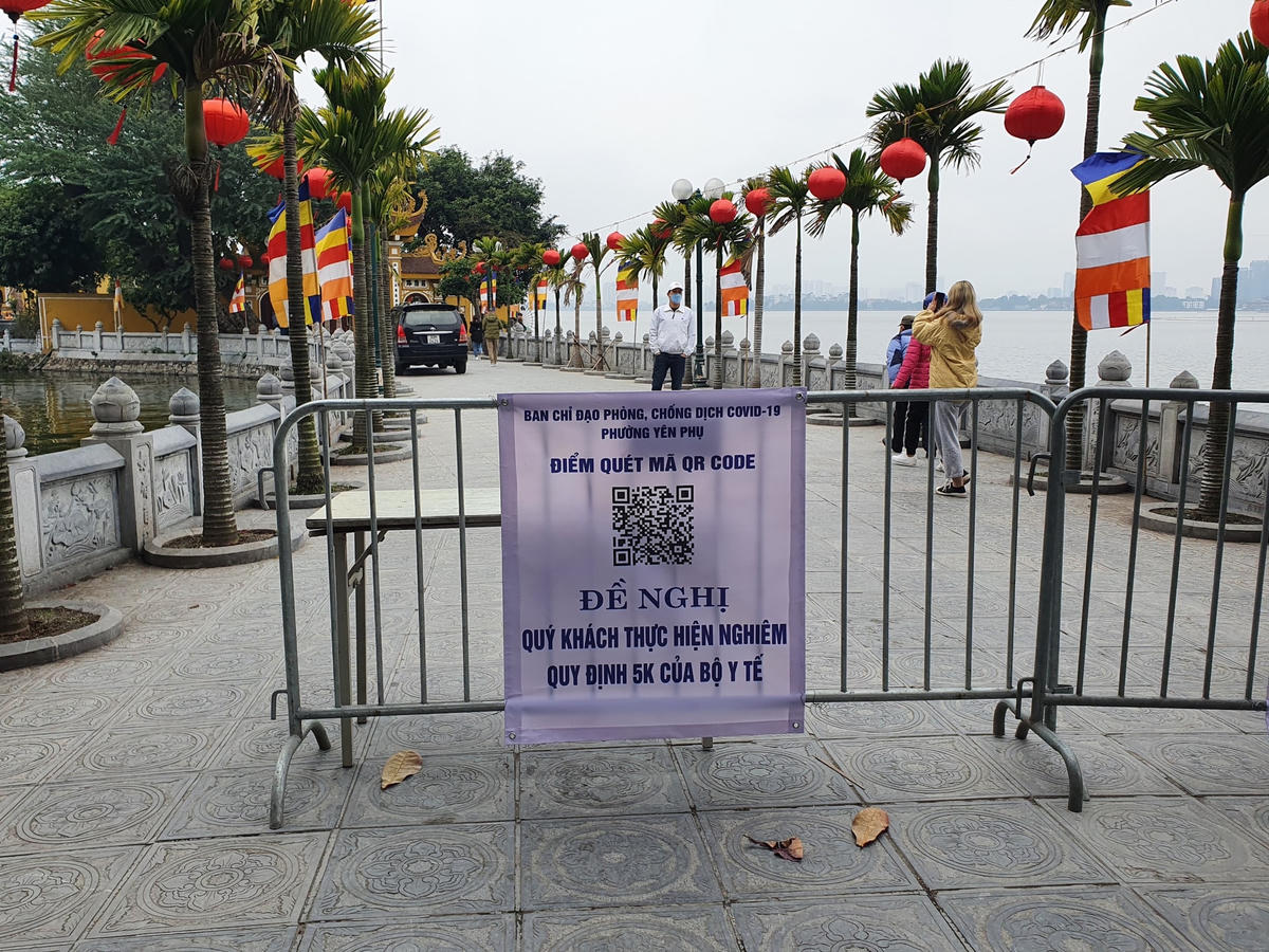 Người dân được yêu cầu khai báo y tế qua mã QR trước khi vào chùa. 