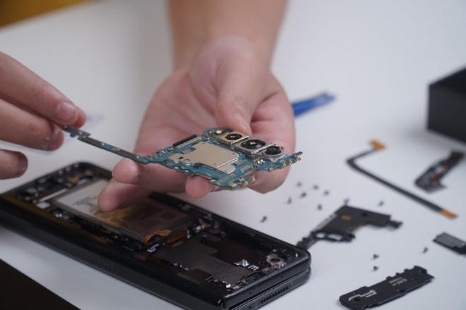 Ngay dưới mặt lưng là các thành phần như sạc không dây, pin, cụm camera chính, bo mạch chính và bo mạch phụ của máy.