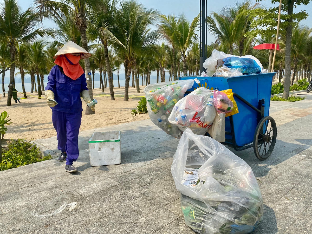 Nhân viên dọn vệ sinh phải luôn tay thu gom rác bị xả bừa bãi trên bãi cát.
