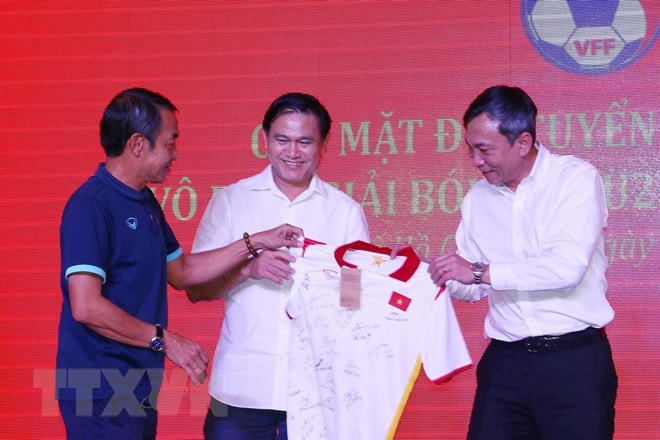 Huấn luyện viên đội U23 Việt Nam Đinh Thế Nam trao tặng chiếc áo có chữ ký của các tuyển thủ U23 Việt Nam, nhà vô địch Giải U23 Đông Nam Á 2022 cho lãnh đạo Liên đoàn bóng đá Việt Nam (Ảnh: Thanh Vũ/TTXVN).