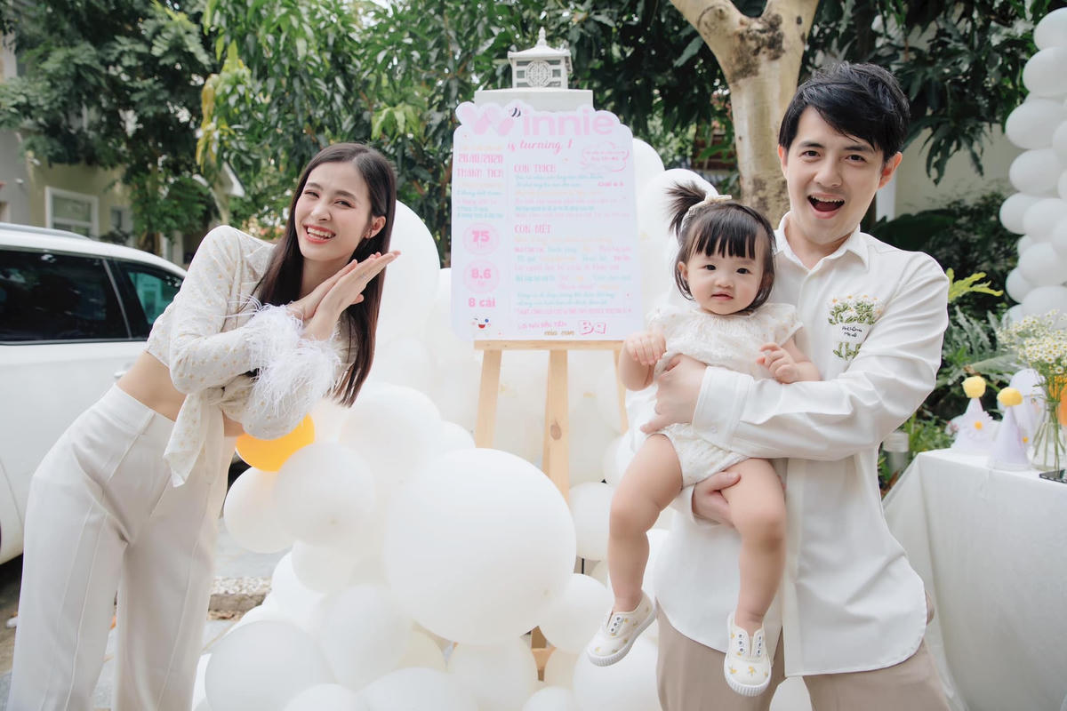 Bố bỉm sữa Ông Cao Thắng chọn áo sơ mi kết hợp với quần âu ra dáng ông bố trưởng thành, chín chắn. Trong khi đó, mẹ Đông Nhi và bé Winnie diện đồ trắng thể hiện sự nữ tính.