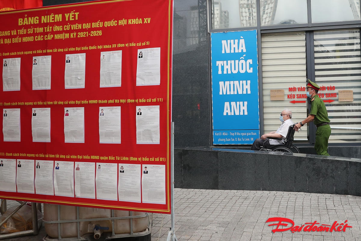 Lực lượng Công an hỗ trợ cử tri cao tuổi vào điểm bỏ phiếu.