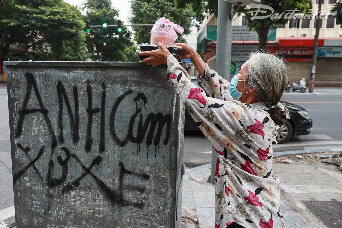 Một người già mang bệnh nặng nhận suất cơm trưa hỗ trợ từ Báo Đại Đoàn Kết. Ảnh: Quang Vinh. 