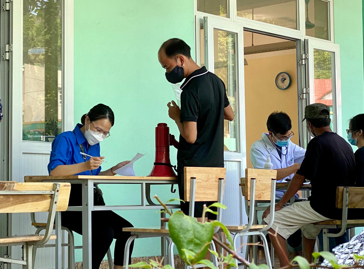 Người dân xếp hàng lần lượt rồi sau đó vào vị trí bàn tiếp đón để khai báo thông tin để tiêm vaccine phòng Covid-19. 