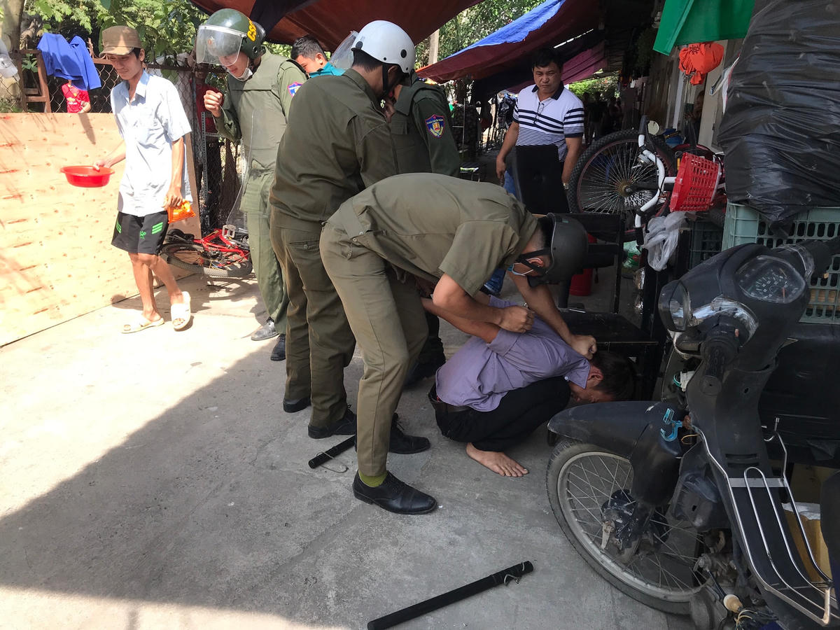 Lực lượng công an và dân phòng không chế Bùi Thiện Em để đưa về trụ sở công an phường. Ảnh TL.