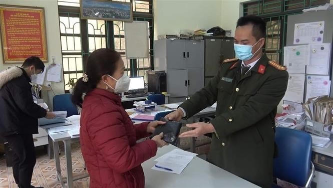 Công an phường Tân Giang (Cao Bằng) trao trả tài sản bị đánh rơi cho bà Hoàng Thị Hương. (Ảnh: TTXVN).