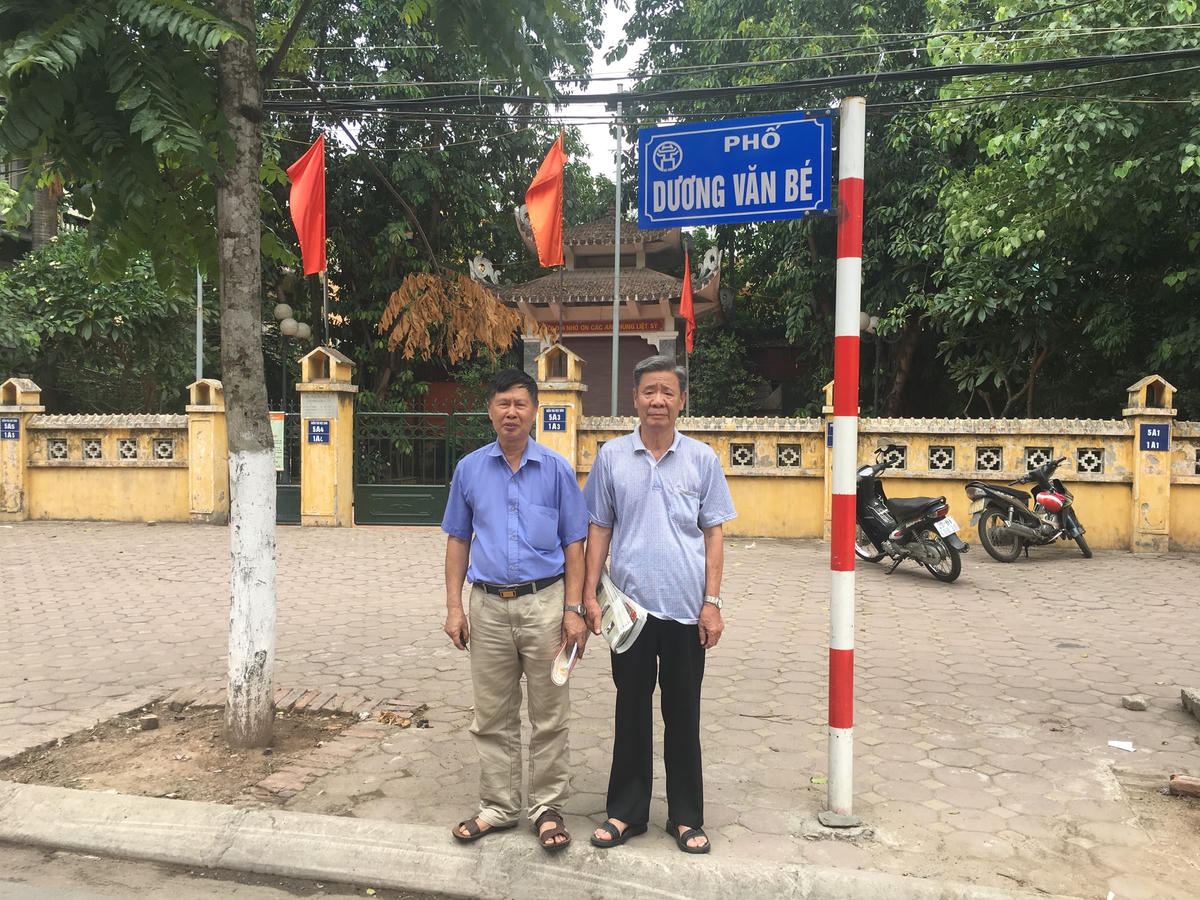 Ông Dương Văn Liệt (bên trái) và ông Dương Văn Côn bên bảng đề tên phố Dương Văn Bé.