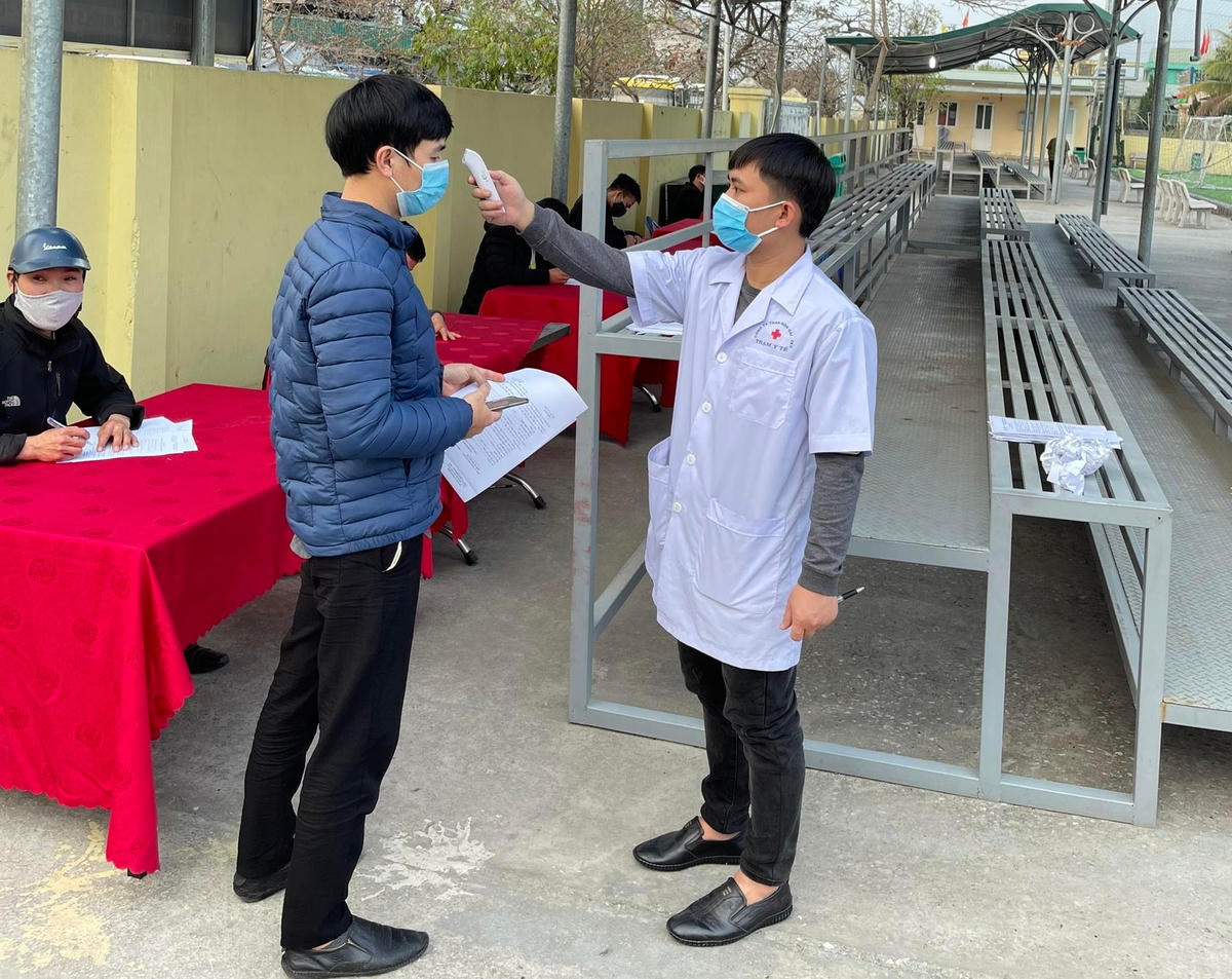 Công ty than Hòn Gai kiểm tra thân nhiệt cho công nhân trước khi vào ca.