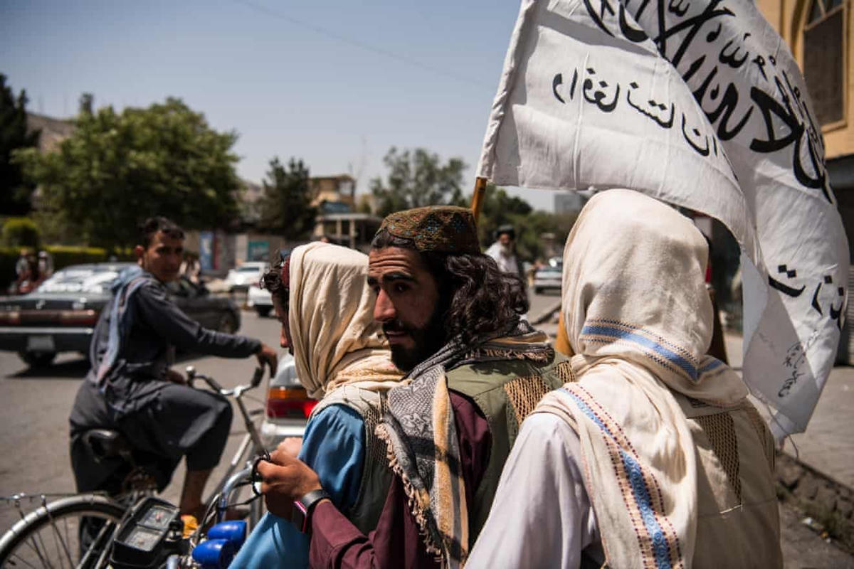 Các chiến binh Taliban mang cờ tuần tra khắp thành phố sau khi kiểm soát được an ninh ở Afghanistan vào đêm 15/8. (Ảnh: Andrew Quilty)